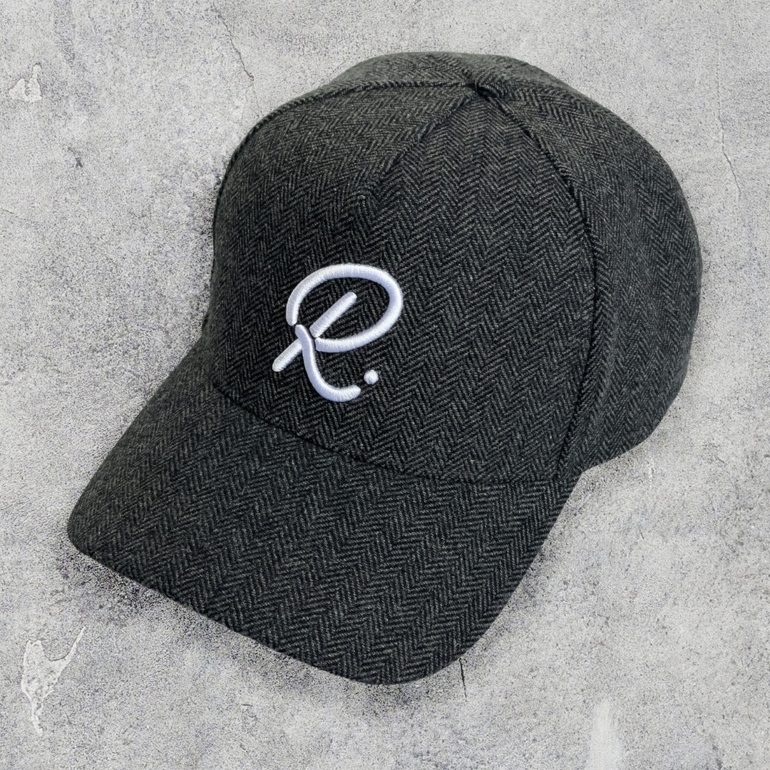 Black cap with a white logo on a textured gray surface