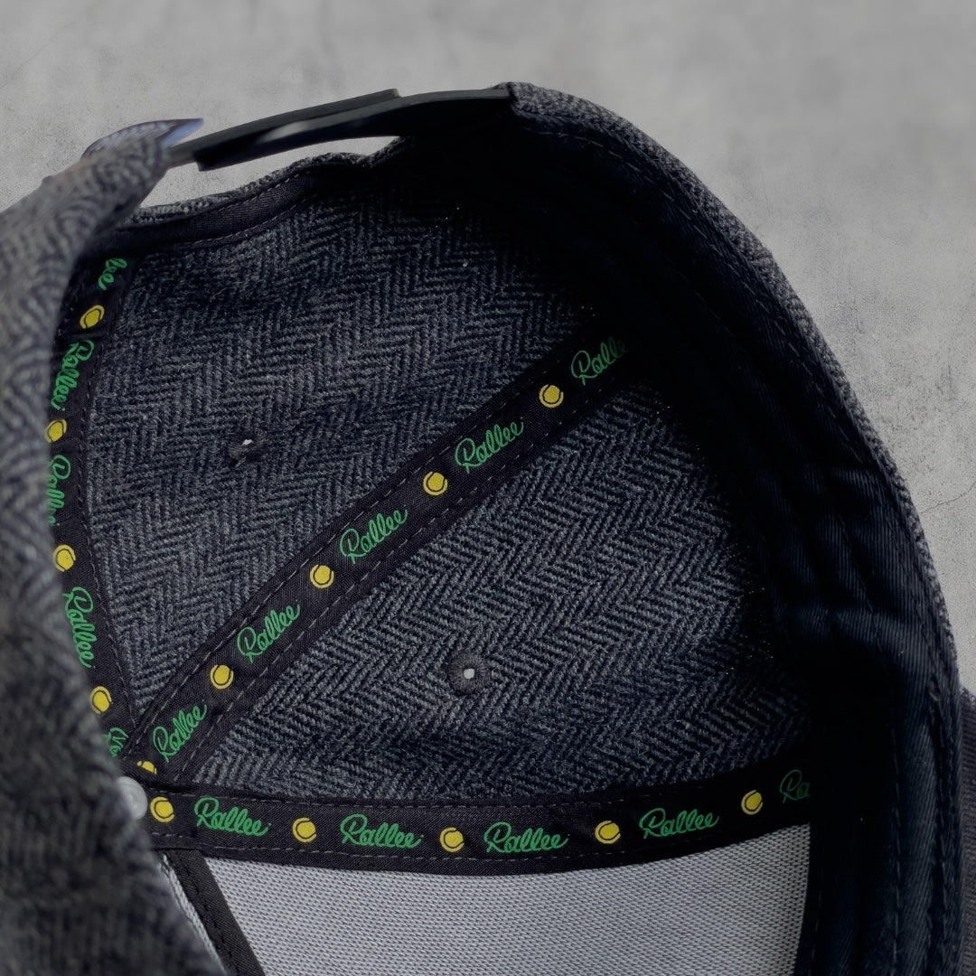 Close-up of a textured bag with a brand logo on a gray background