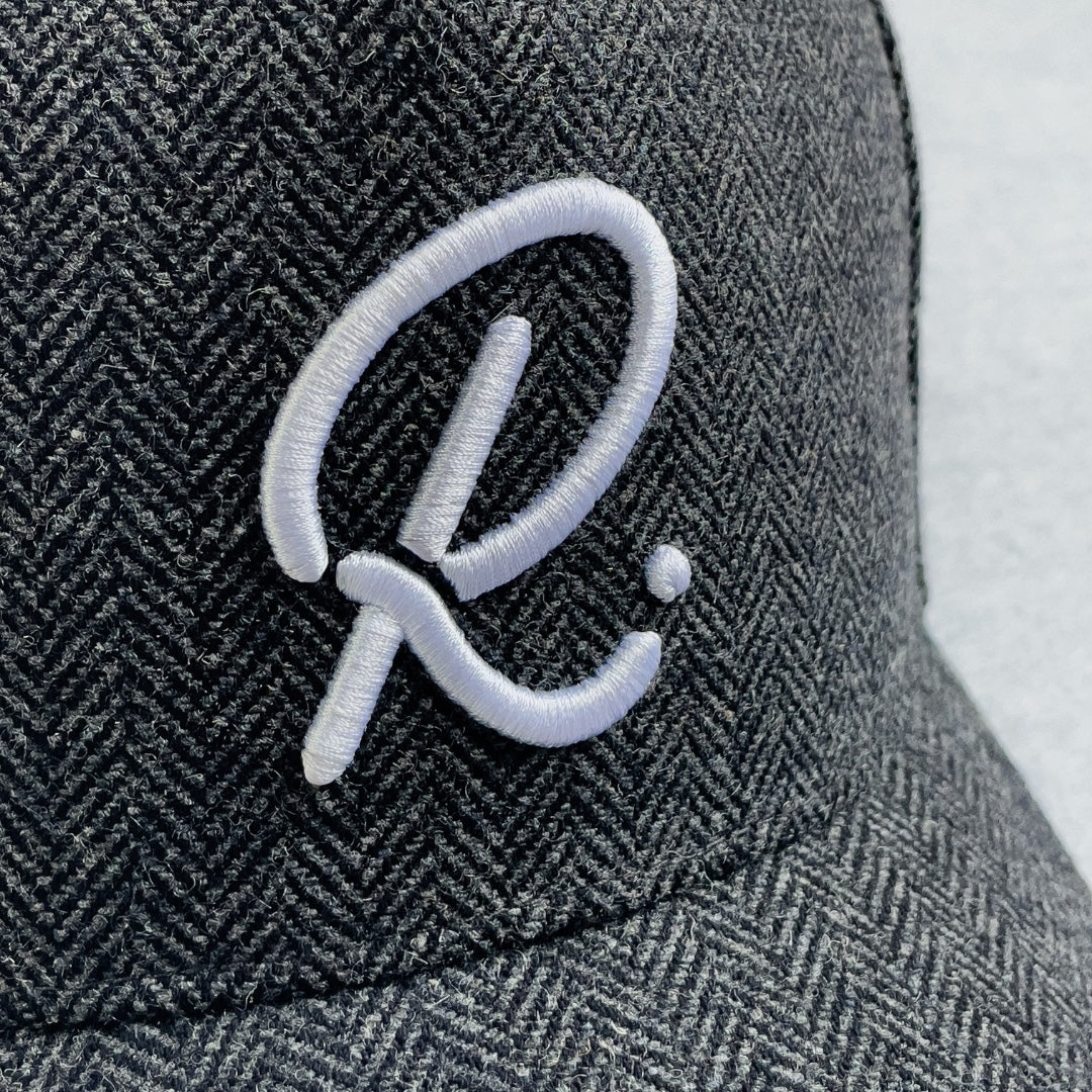 Gray textured cap with a white embroidered logo on a light gray background