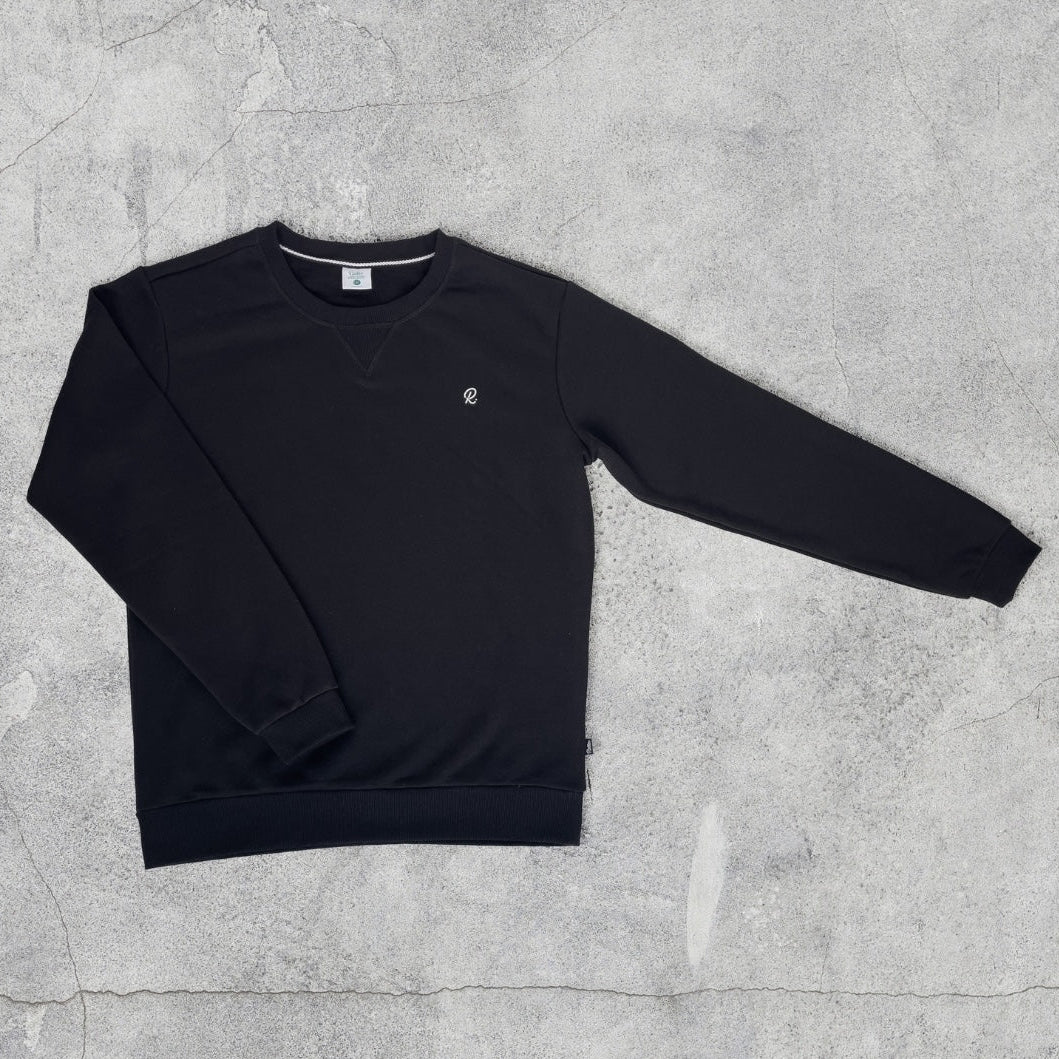 Black sweatshirt on a textured gray surface