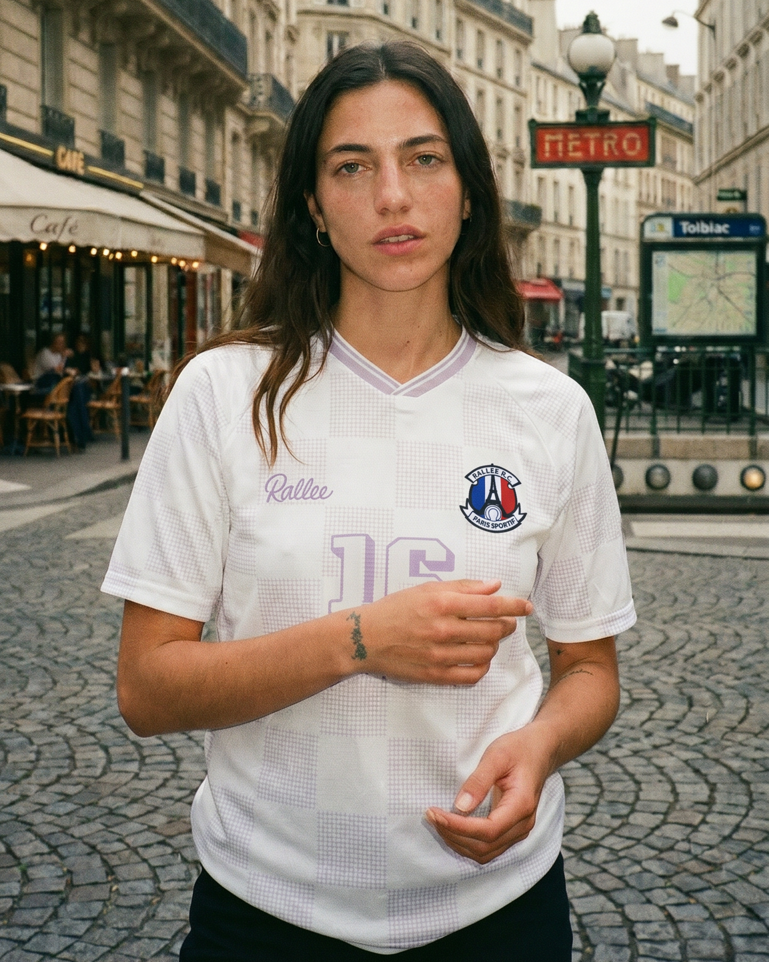 Woman wearing a white sports jersey with Rallee logo on a Paris street.