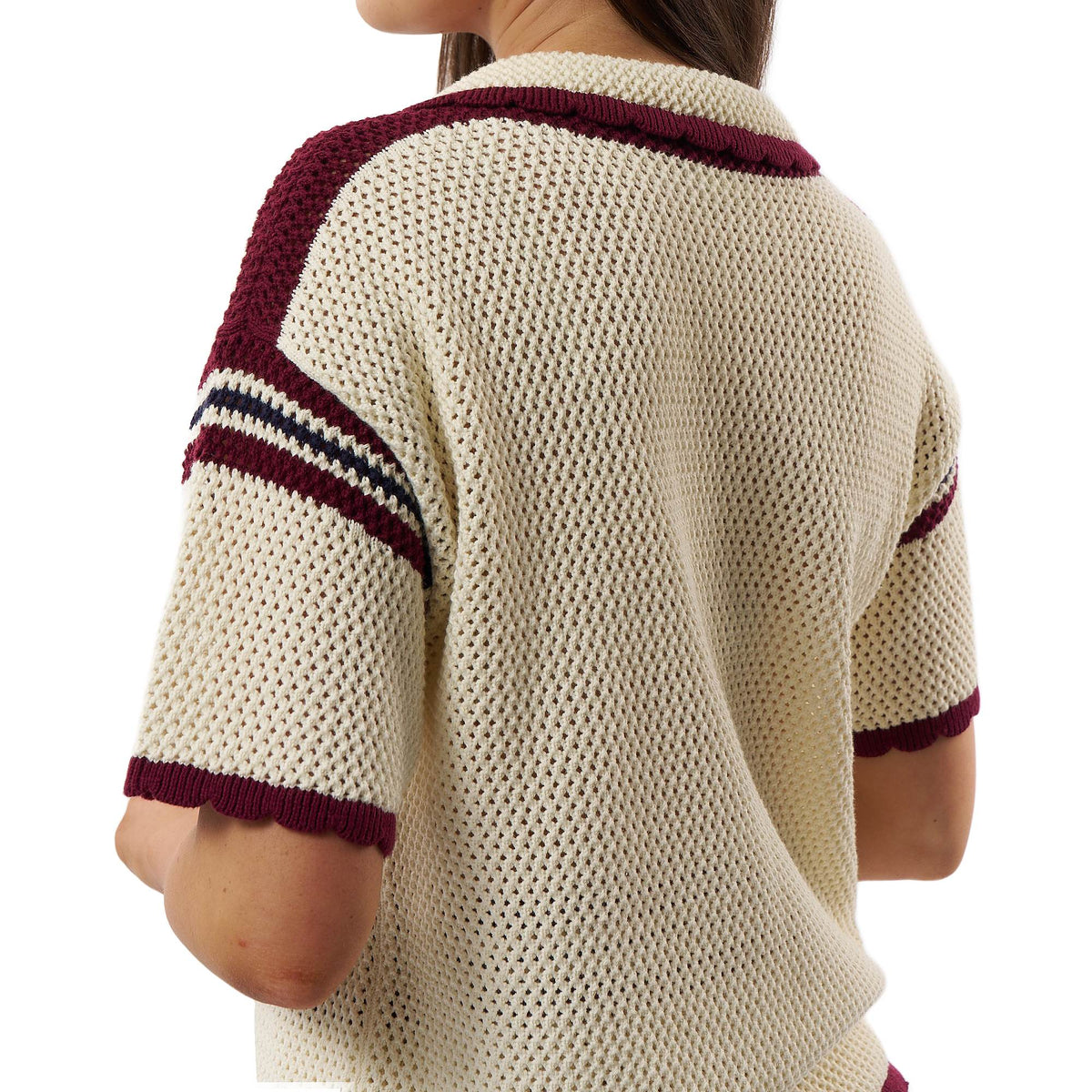 A woman wearing a cream-colored knit short-sleeve sweater with burgundy and navy striped accents on the shoulders and sleeves, shown from the back against a white background.